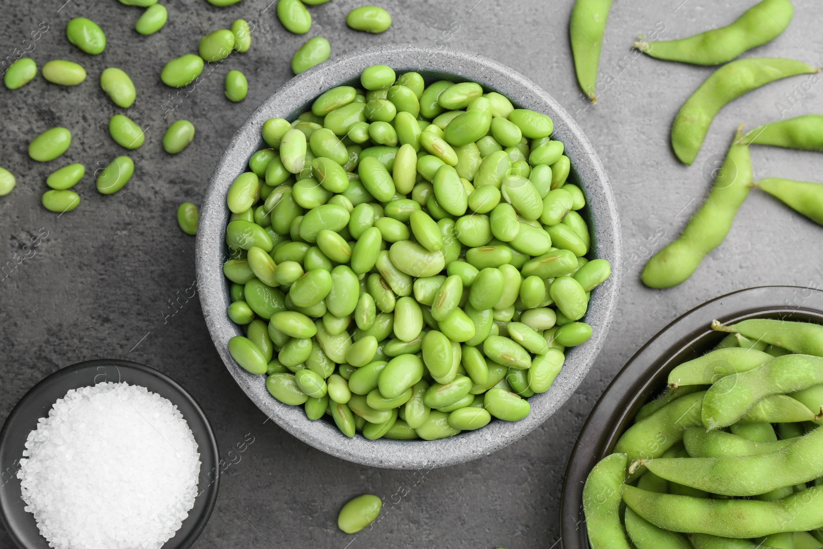 Photo of Raw green edamame soybeans and pods on grey table, flat lay