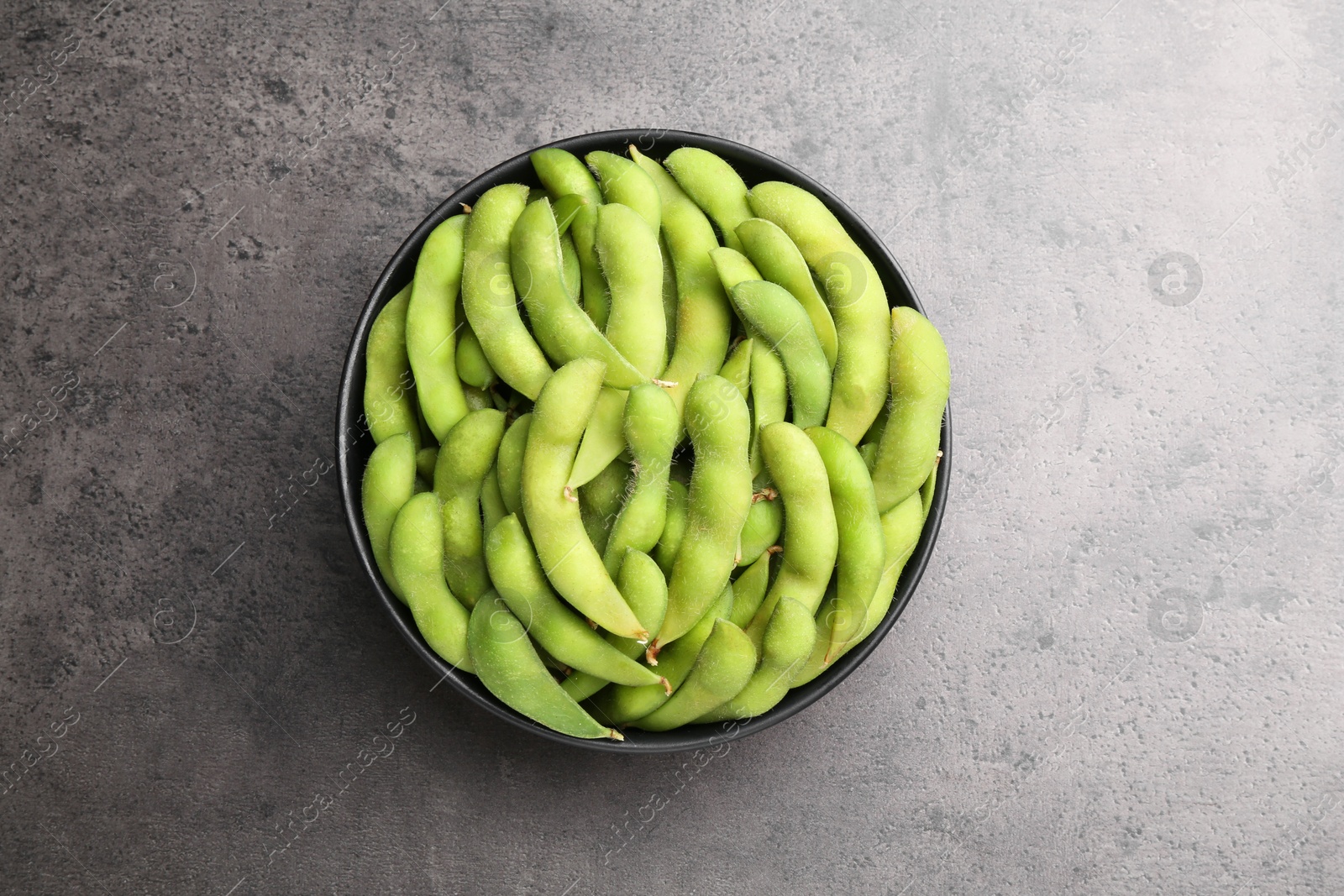 Photo of Raw green edamame soybeans on grey table, top view