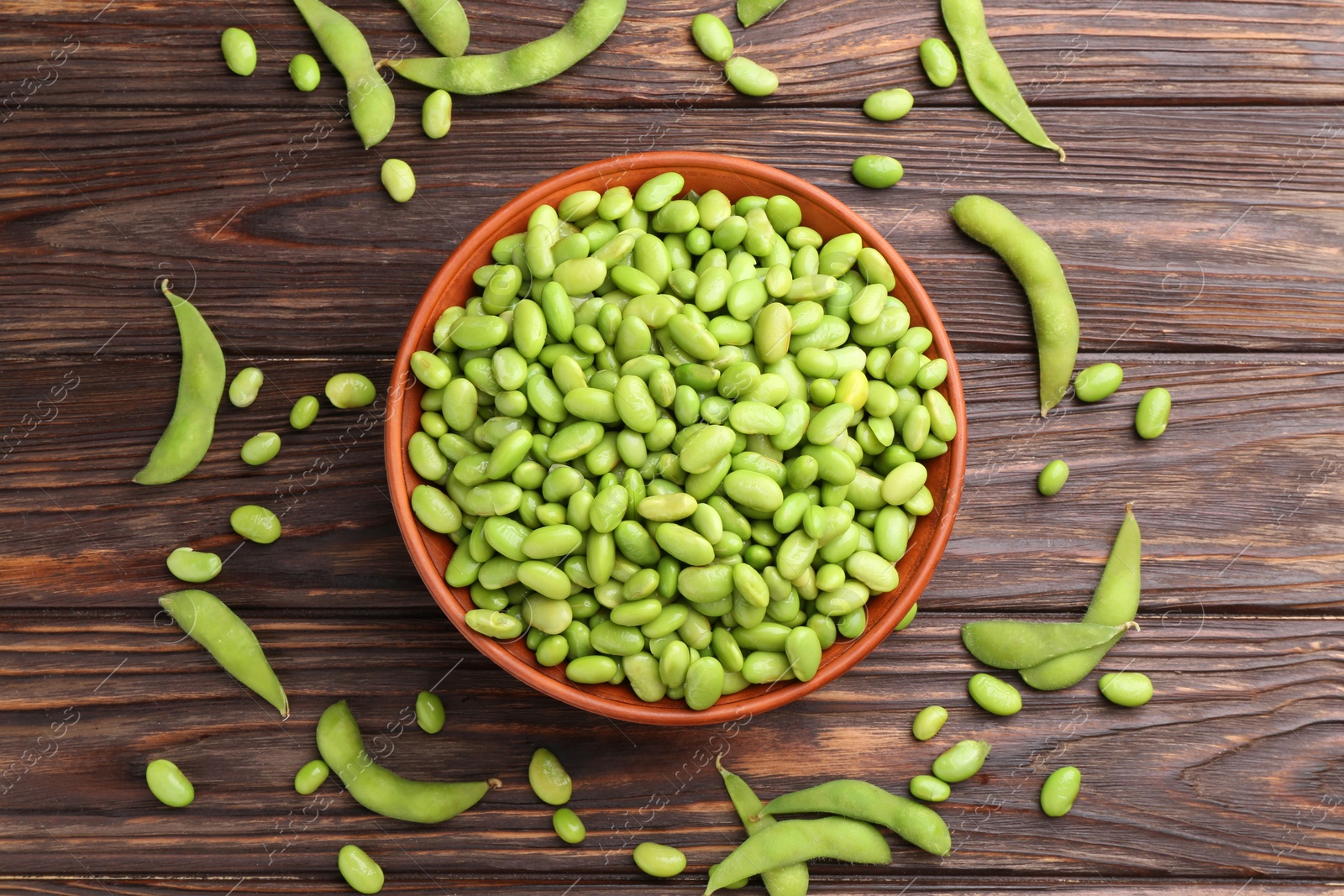 Photo of Raw green edamame soybeans and pods on wooden table, flat lay