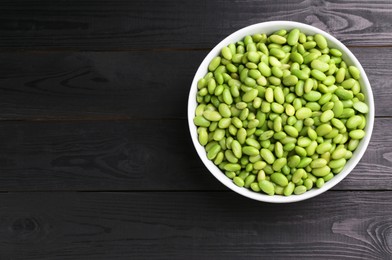 Photo of Raw green edamame soybeans on wooden table, top view. Space for text