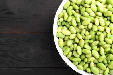 Photo of Raw green edamame soybeans on wooden table, top view. Space for text