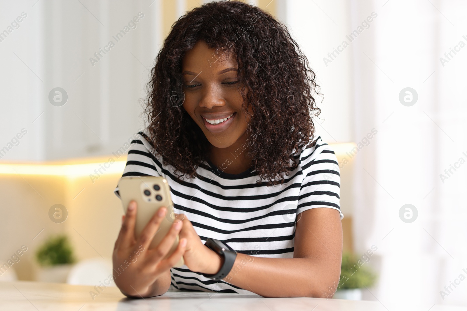 Photo of Beautiful woman using mobile phone at table indoors