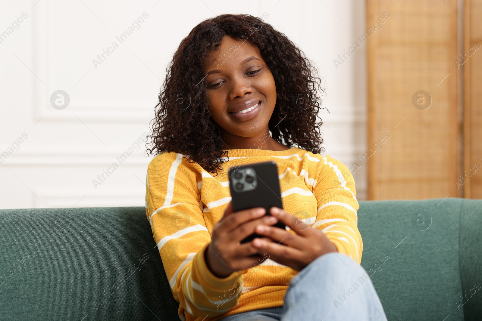 Photo of Beautiful woman using mobile phone at home