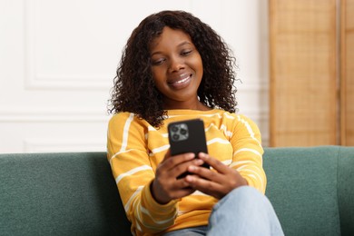 Photo of Beautiful woman using mobile phone at home