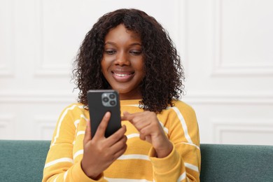 Beautiful woman using mobile phone at home