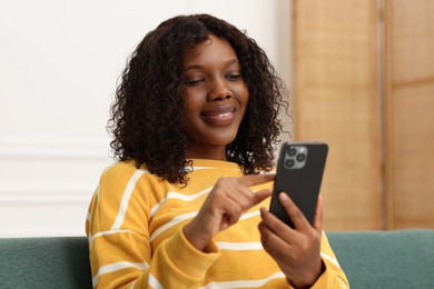 Photo of Beautiful woman using mobile phone at home