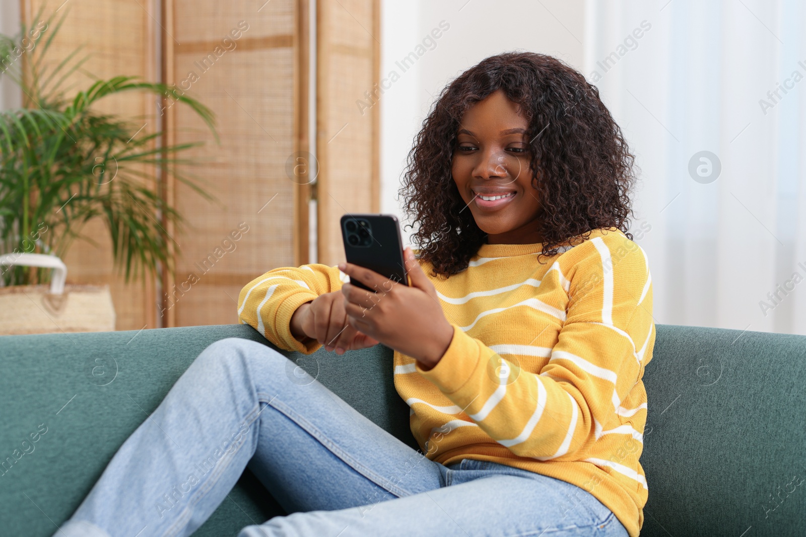 Photo of Beautiful woman using mobile phone at home