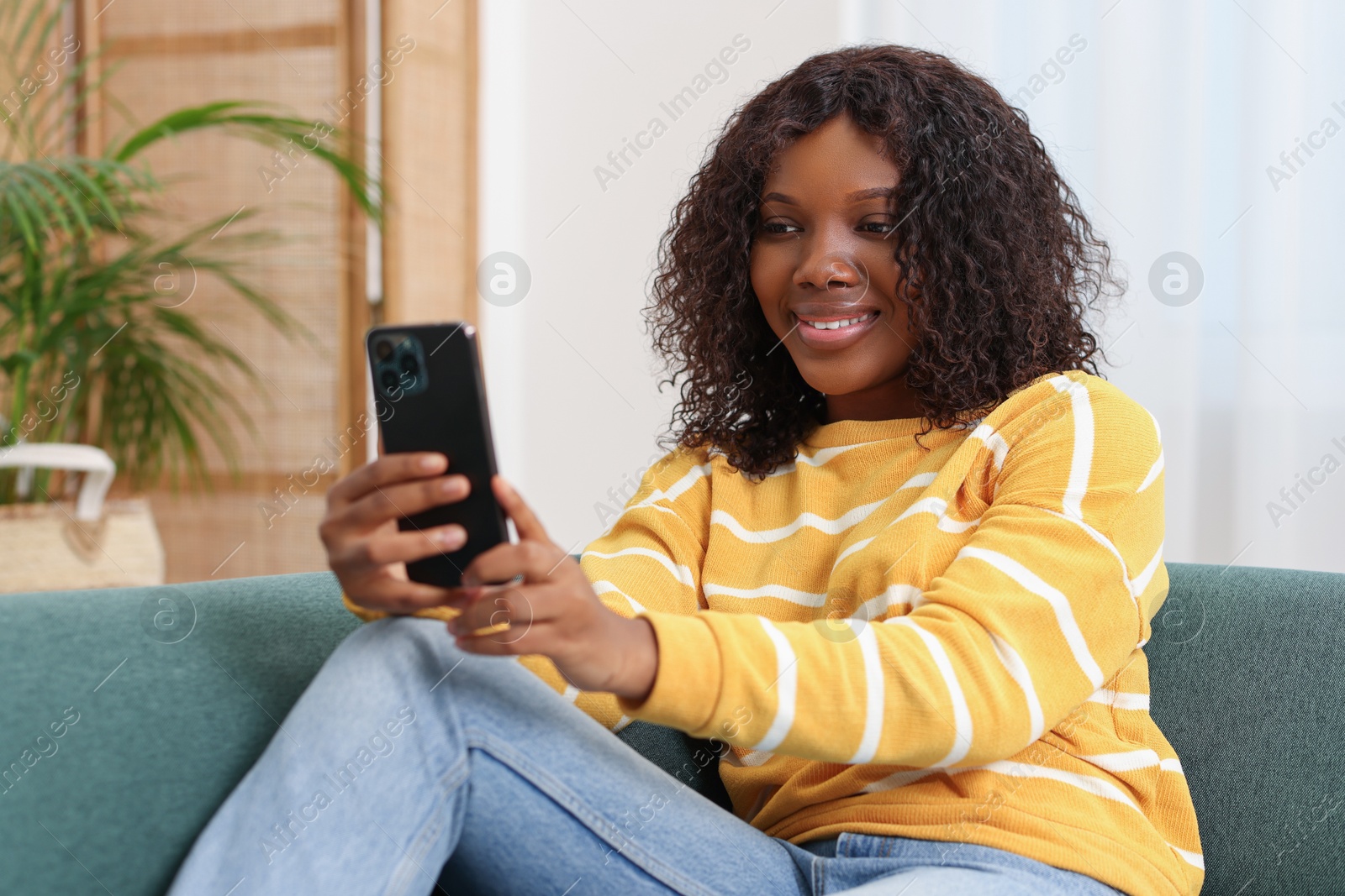 Photo of Beautiful woman using mobile phone at home