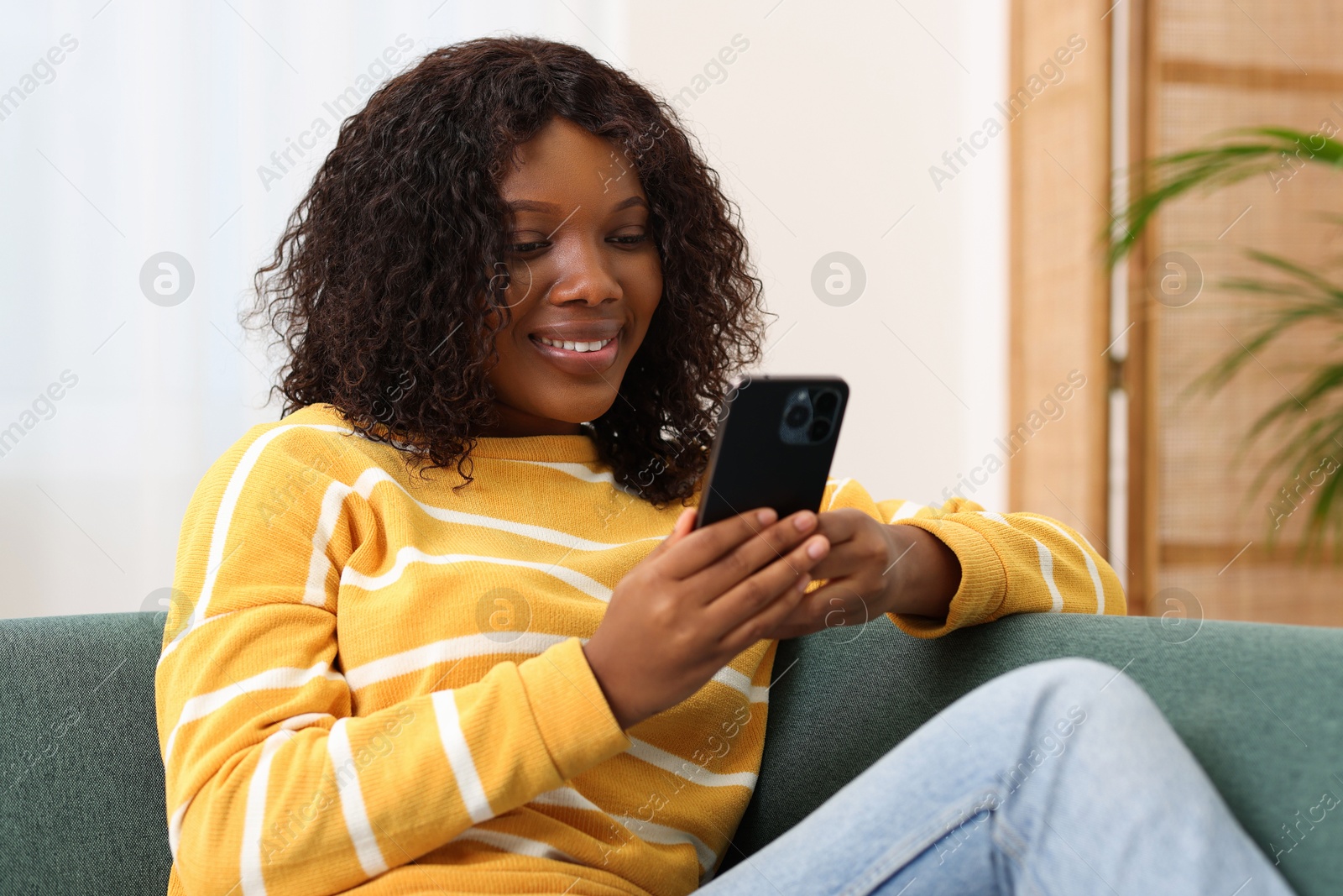 Photo of Beautiful woman using mobile phone at home