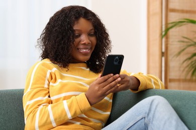 Photo of Beautiful woman using mobile phone at home