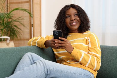 Photo of Beautiful woman using mobile phone at home