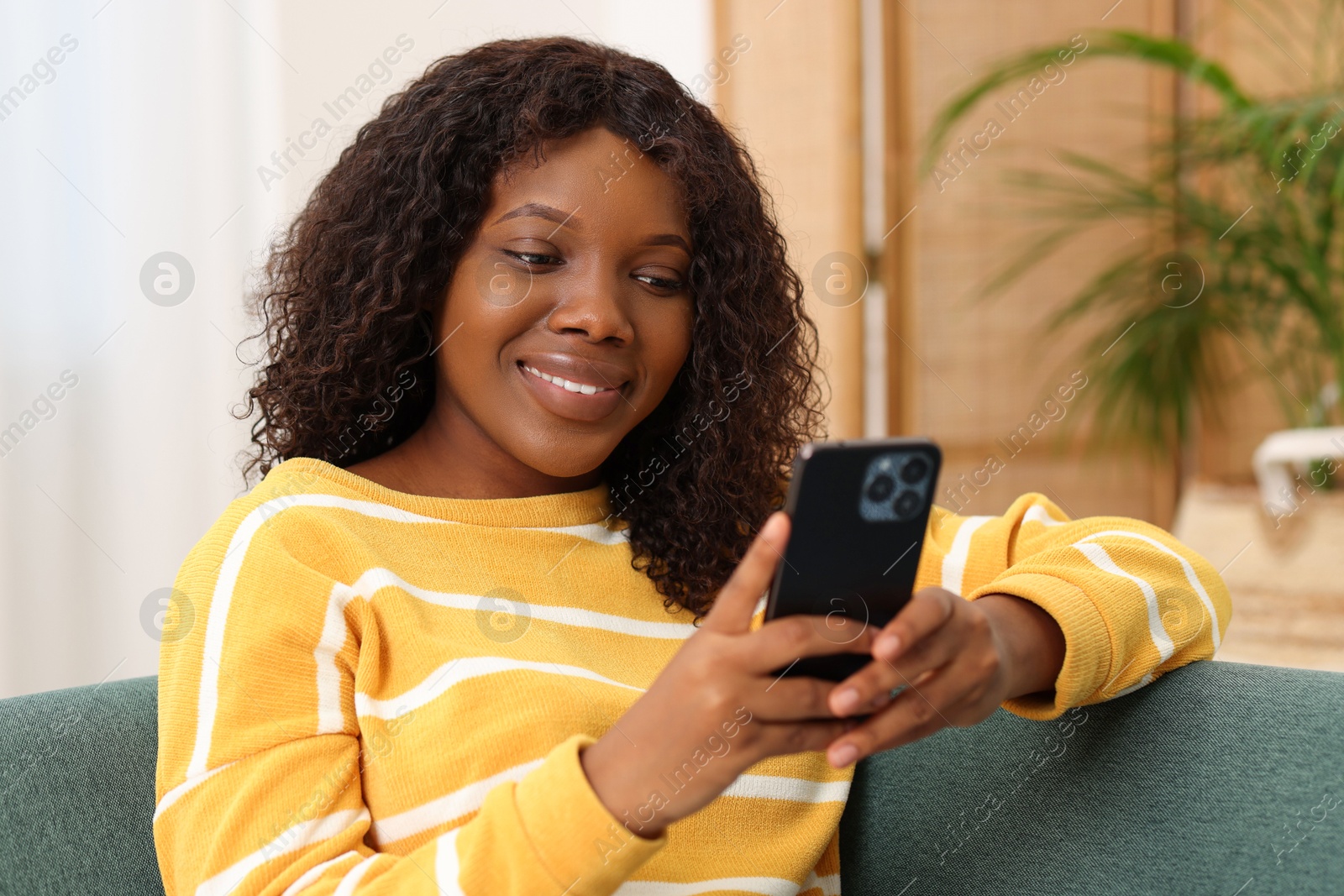 Photo of Beautiful woman using mobile phone at home