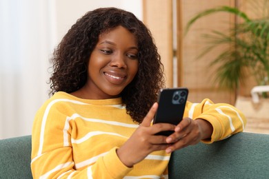 Photo of Beautiful woman using mobile phone at home