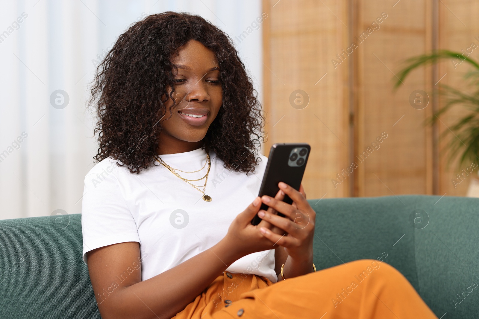 Photo of Beautiful woman using mobile phone at home