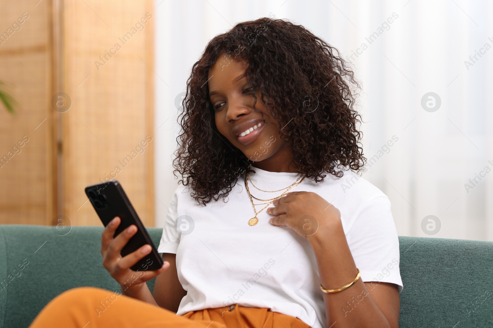 Photo of Beautiful woman using mobile phone at home