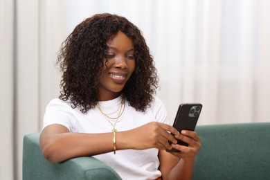 Photo of Beautiful woman using mobile phone at home