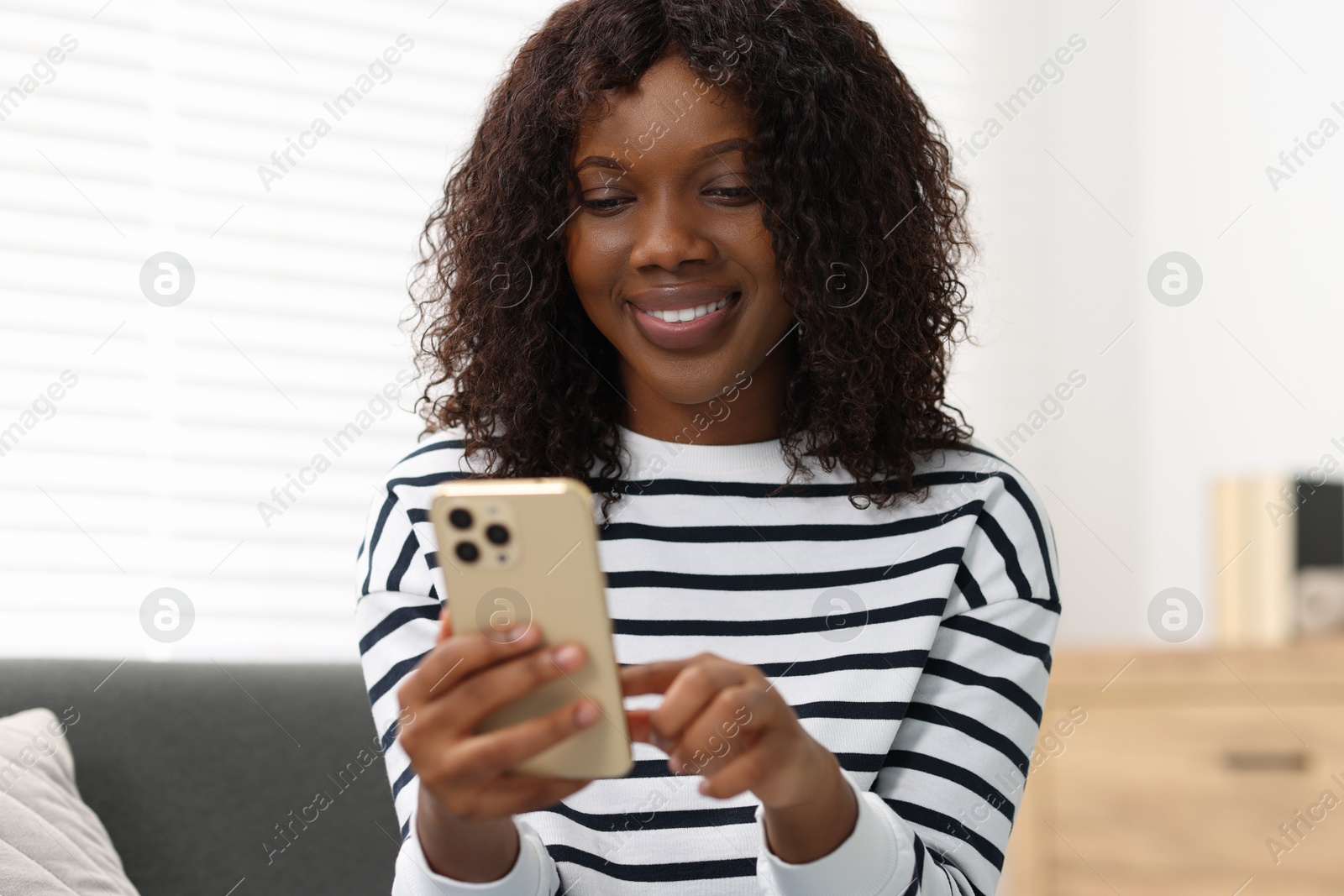 Photo of Beautiful woman using mobile phone at home