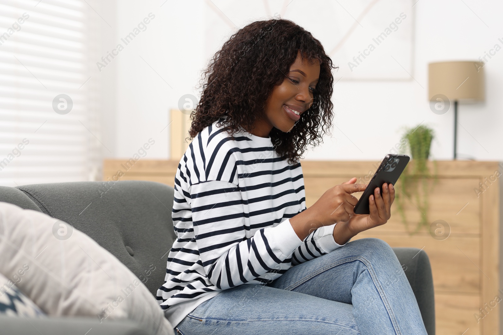 Photo of Beautiful woman using mobile phone at home