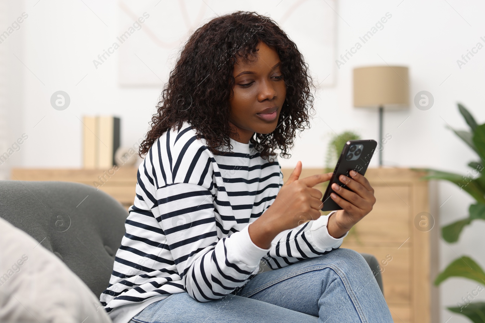 Photo of Beautiful woman using mobile phone at home