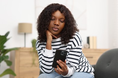 Photo of Beautiful woman using mobile phone at home