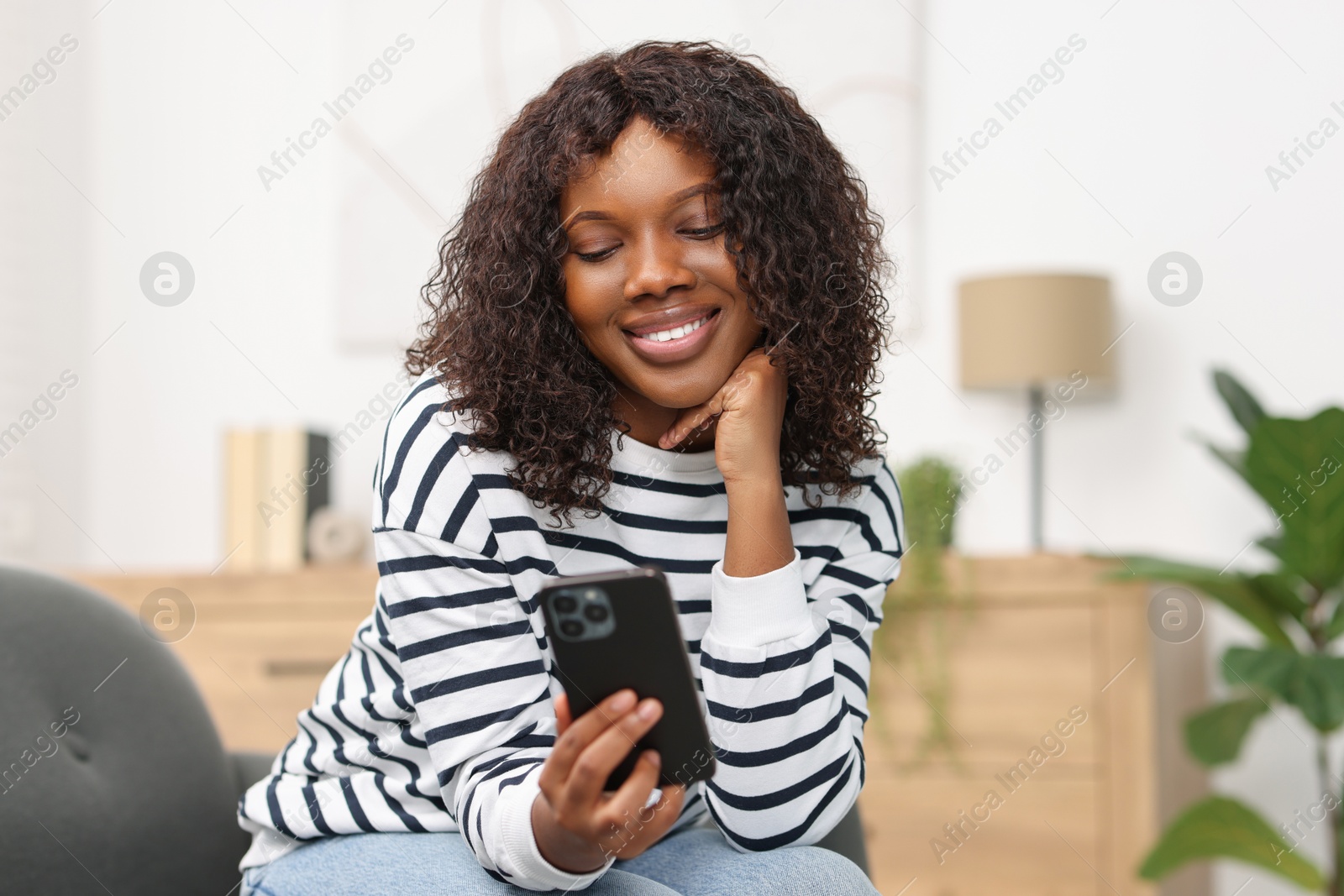 Photo of Beautiful woman using mobile phone at home