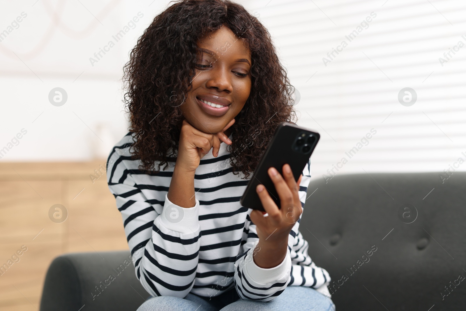 Photo of Beautiful woman using mobile phone at home