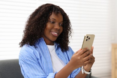 Photo of Beautiful woman using mobile phone at home