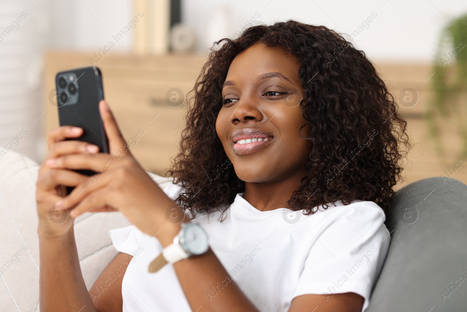 Photo of Beautiful woman using mobile phone at home