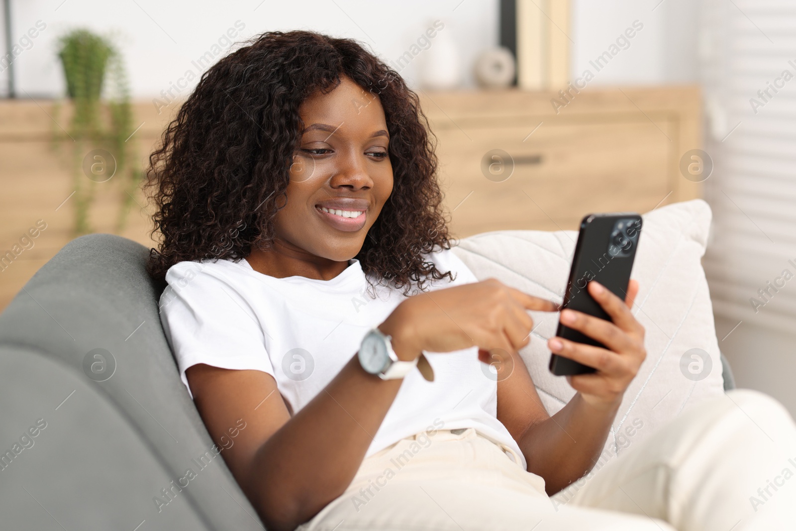 Photo of Beautiful woman using mobile phone at home