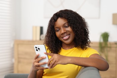 Photo of Beautiful woman using mobile phone at home