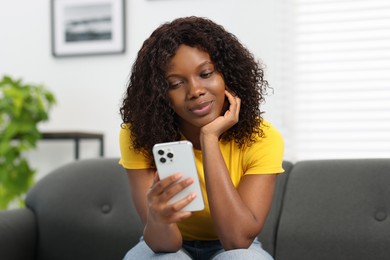 Photo of Beautiful woman using mobile phone at home