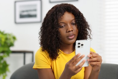 Photo of Beautiful woman using mobile phone at home