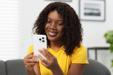 Beautiful woman using mobile phone at home