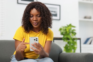 Photo of Beautiful woman using mobile phone at home