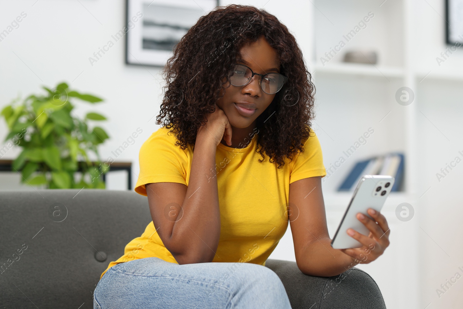 Photo of Beautiful woman using mobile phone at home