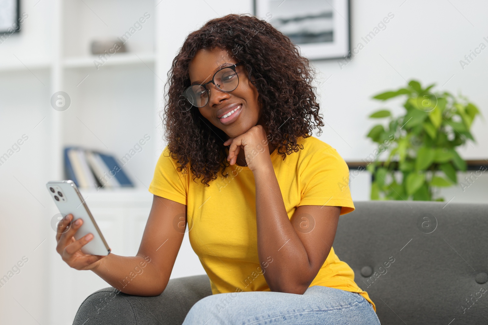 Photo of Beautiful woman using mobile phone at home