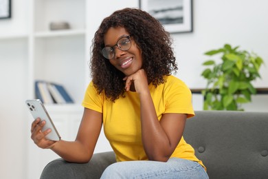 Photo of Beautiful woman using mobile phone at home