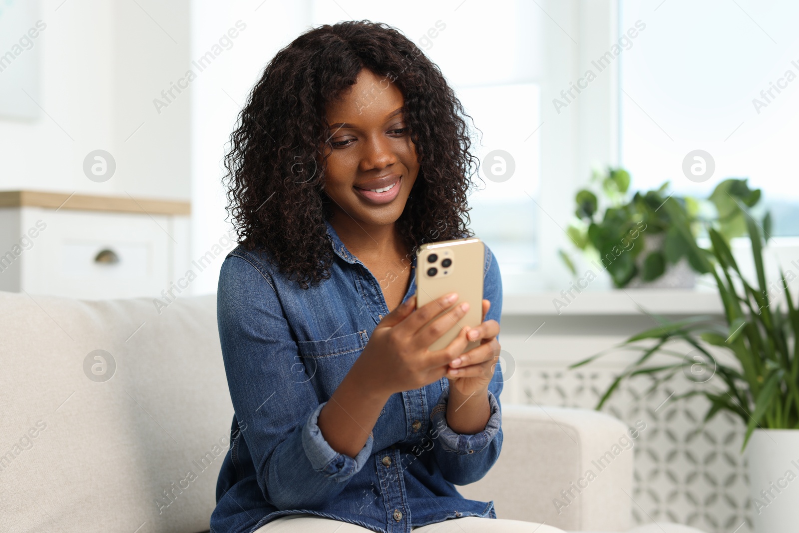 Photo of Beautiful woman using mobile phone at home