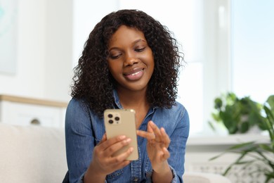 Beautiful woman using mobile phone at home