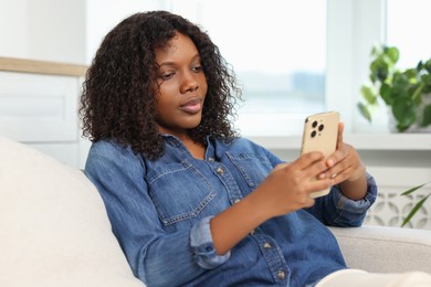 Photo of Beautiful woman using mobile phone at home