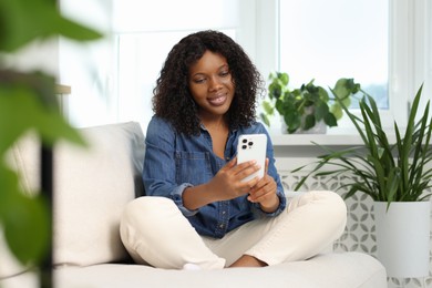 Photo of Beautiful woman using mobile phone at home