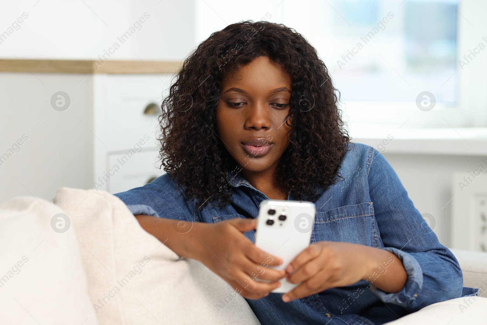 Photo of Beautiful woman using mobile phone at home