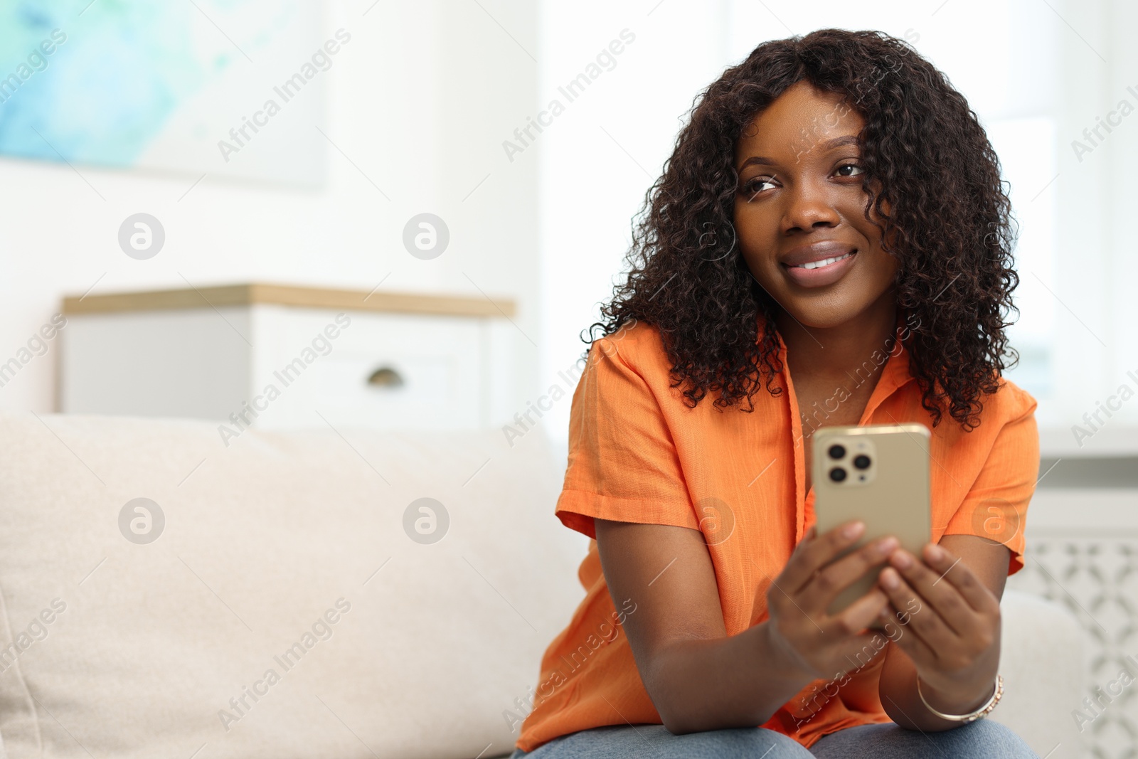 Photo of Beautiful woman using mobile phone at home, space for text