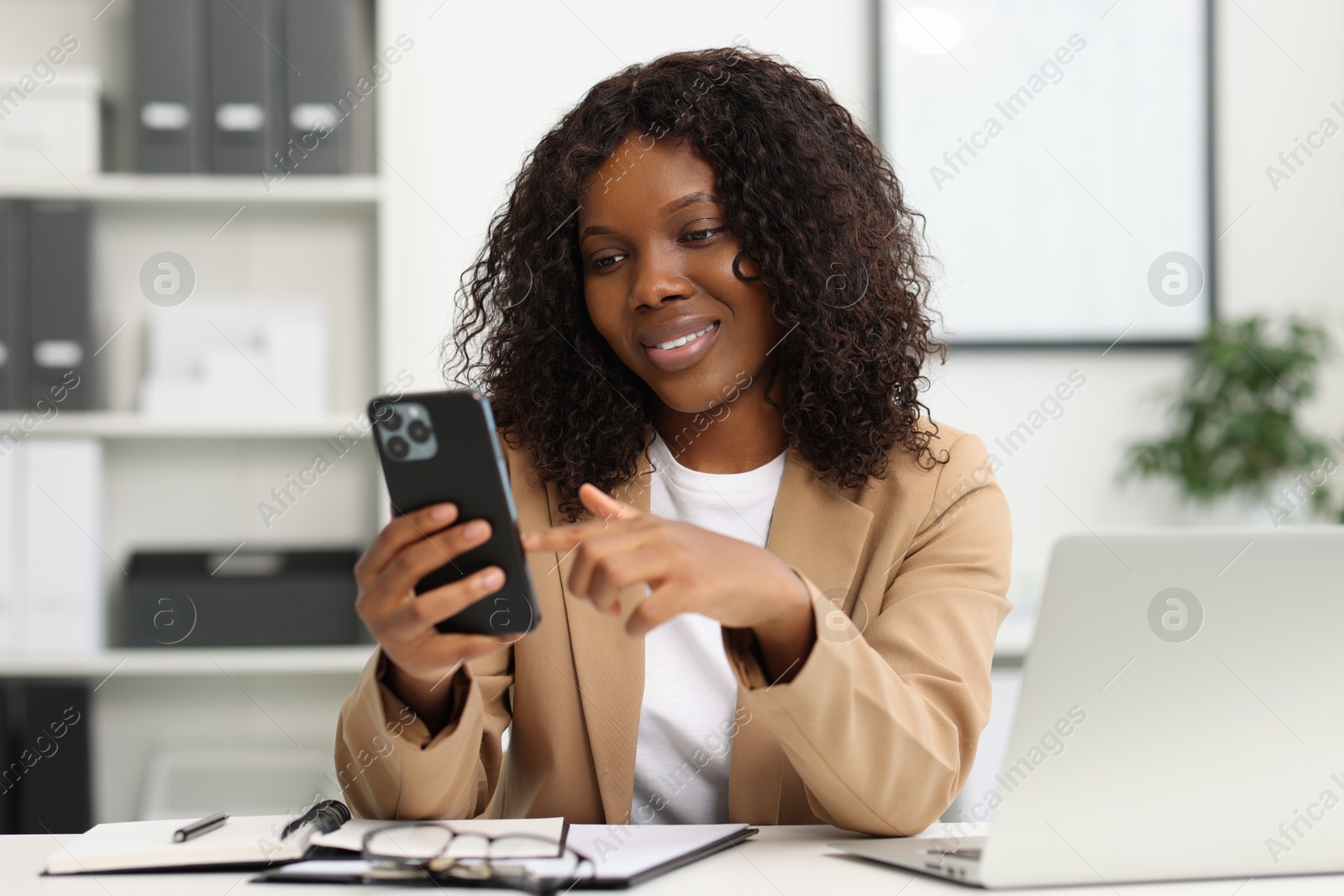 Photo of Beautiful woman using mobile phone in office