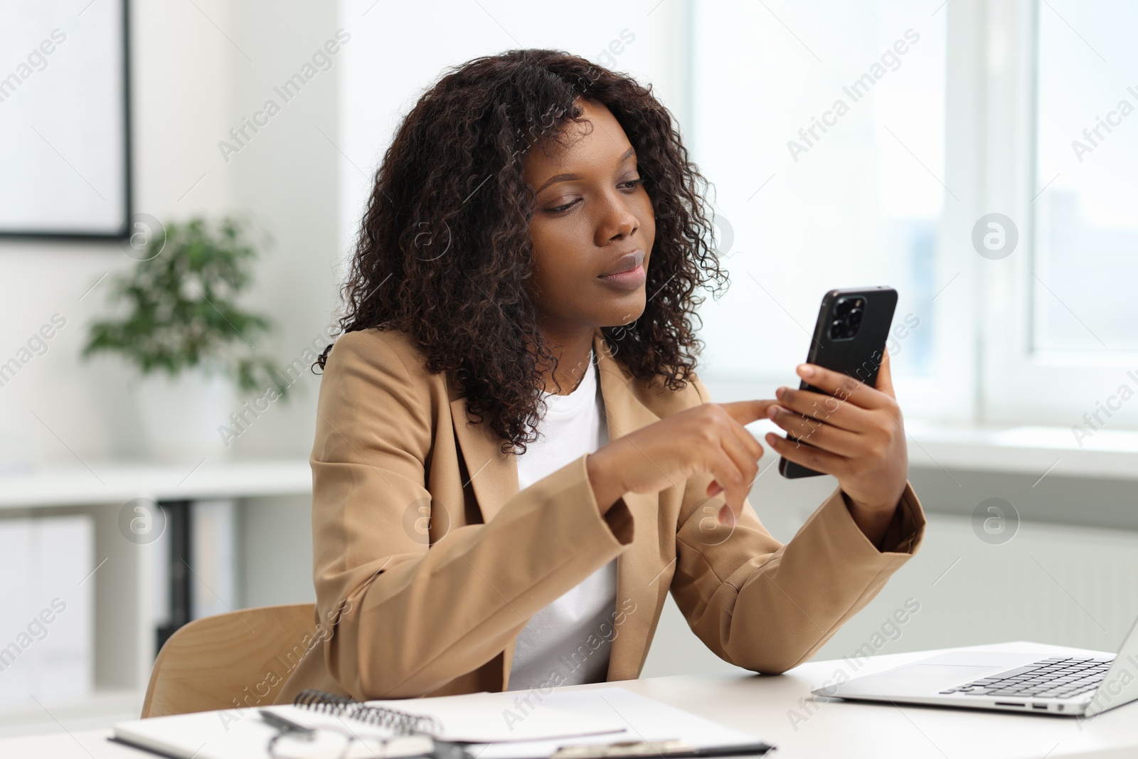 Photo of Beautiful woman using mobile phone in office