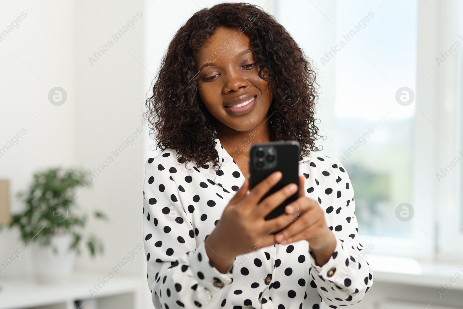 Photo of Beautiful woman using mobile phone at home