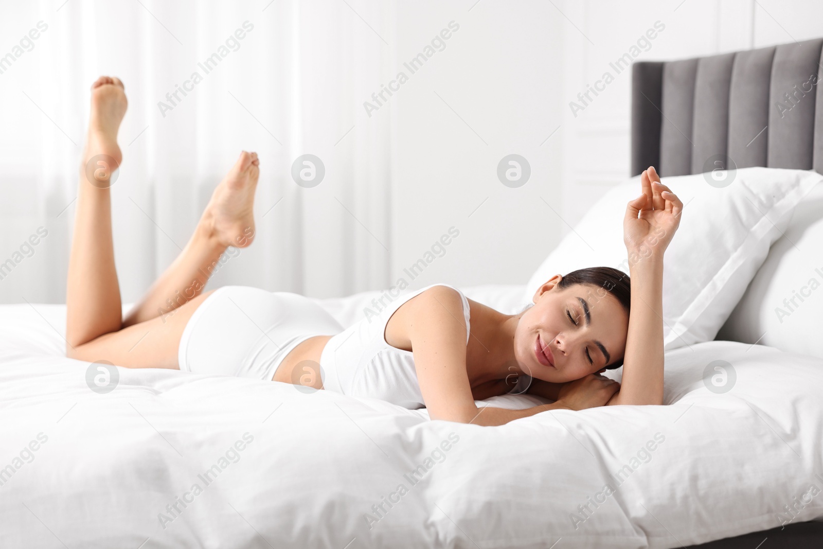 Photo of Beautiful woman with perfect skin in underwear on bed. Body care