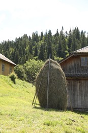 Pile of hay near barn on farmland