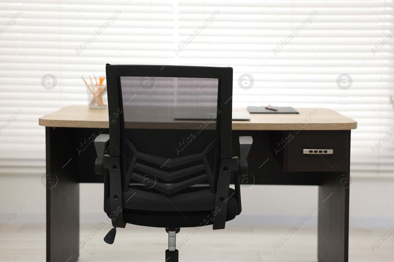 Photo of Black chair, laptop and desk in office