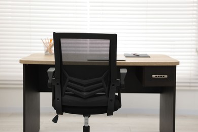 Black chair, laptop and desk in office